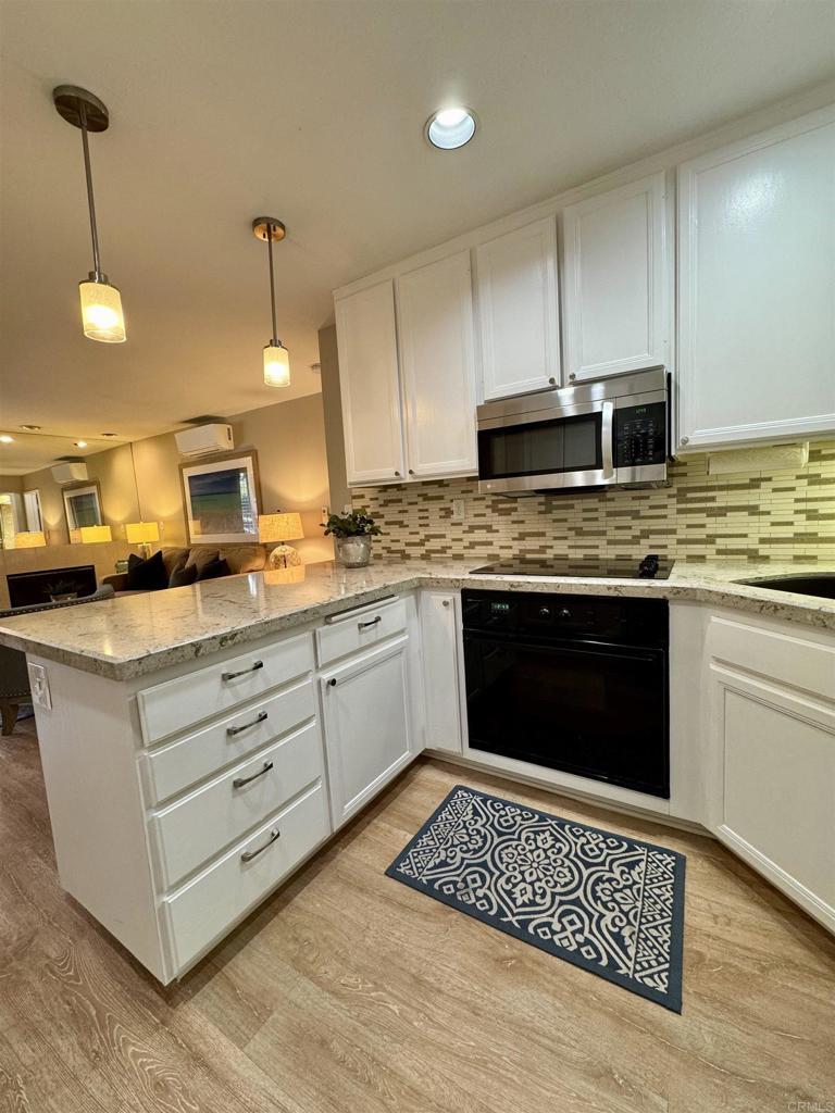 Kitchen detail with stainless appliances and tile backsplash.