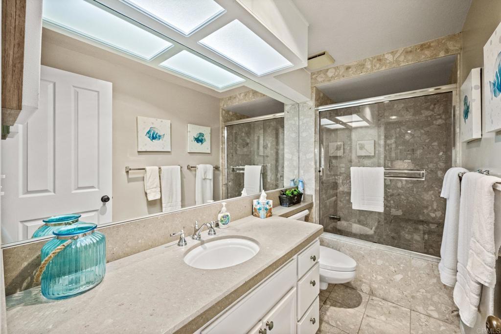 Refreshed bathroom with walk-in shower and stone vanity.