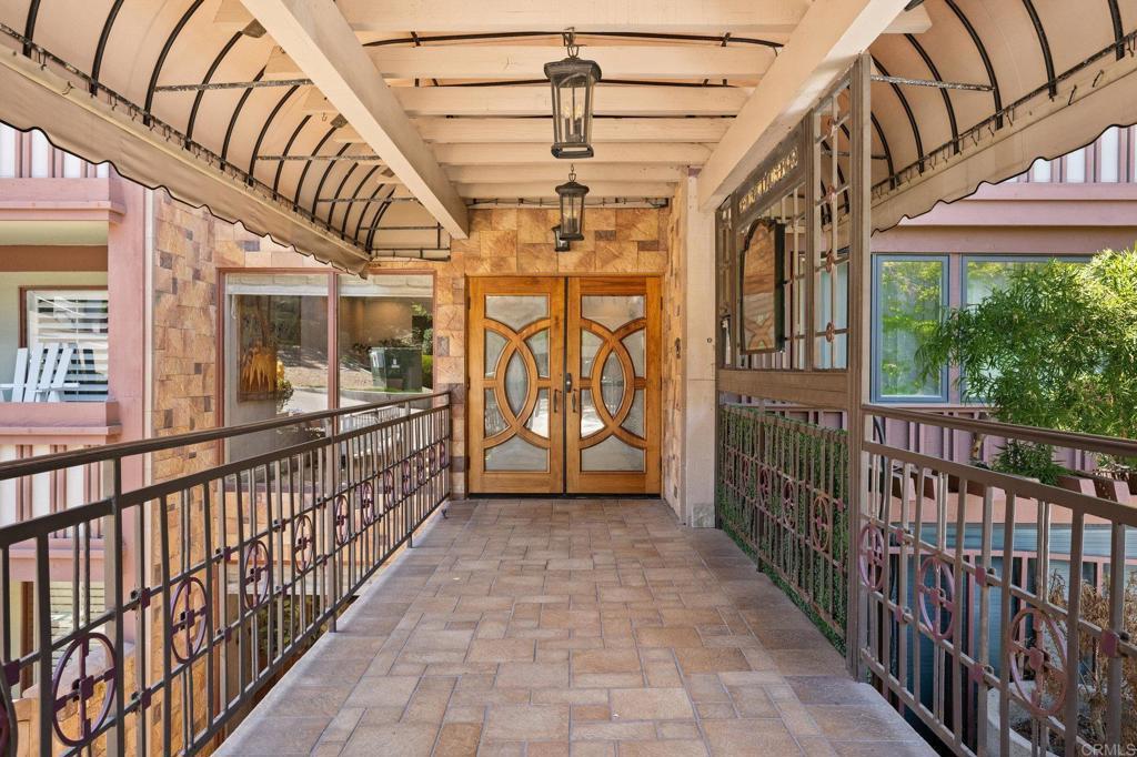 Covered walkway with custom iron railing and lantern entry.